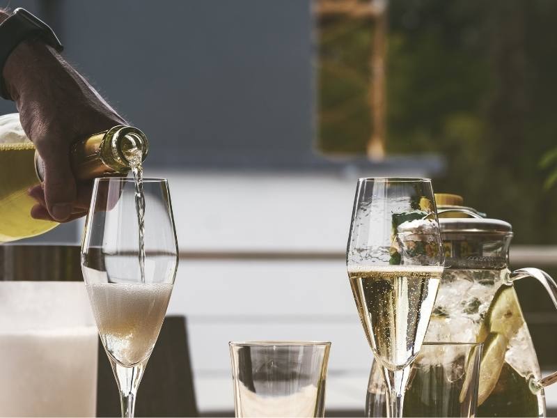 man pouring champagne into a champagne glass