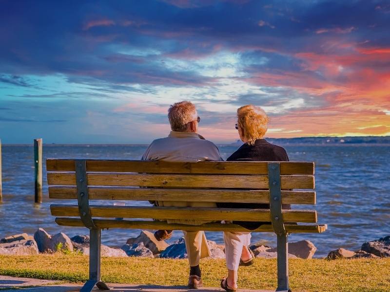 man and woman enjoying their retirement watching the sunset